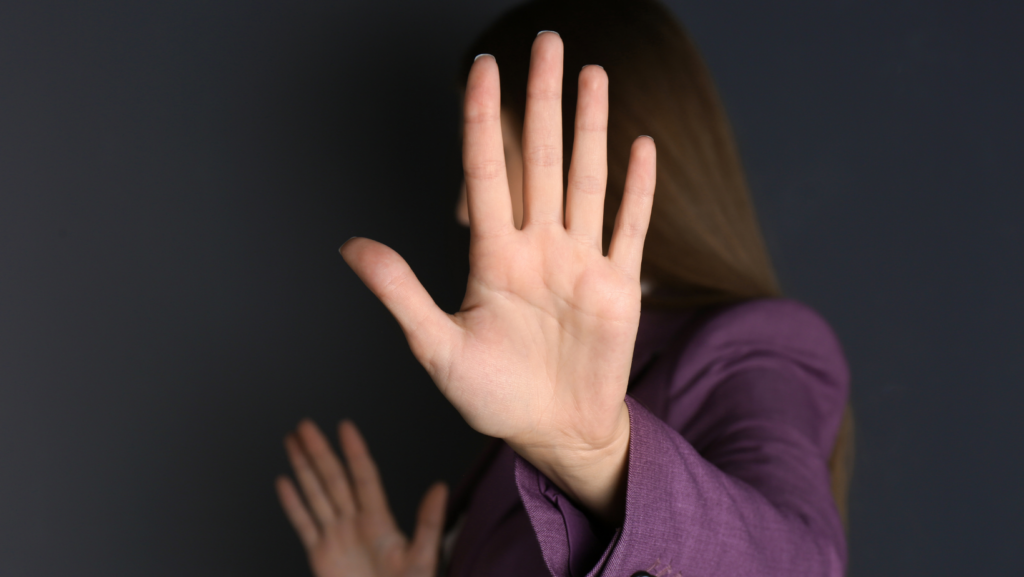 women putting her hand up to defend herself