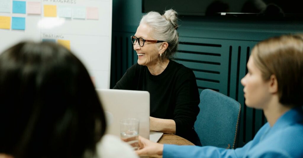 woman-in-black-sweater-and-eyeglasses-sitting-on-chair-beside-woman-in-blue-shirt